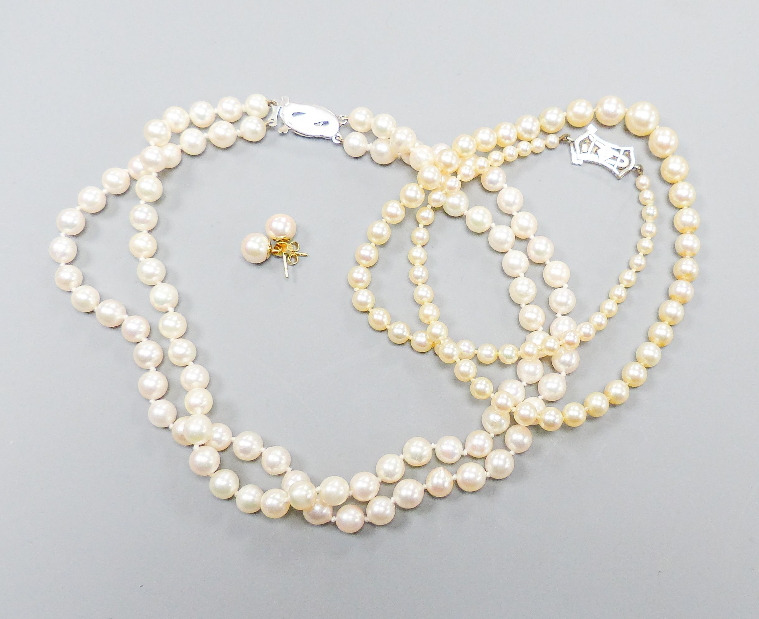 A single strand graduated cultured pearl necklace, with diamond set 9ct clasp, 43cm, a double strand cultured pearl choker necklace, with marcasite set clasp, 32cm and a pair of cultured pearl ear studs.